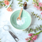 baking soda in a teal bowl with flowers around to make diy face scrub