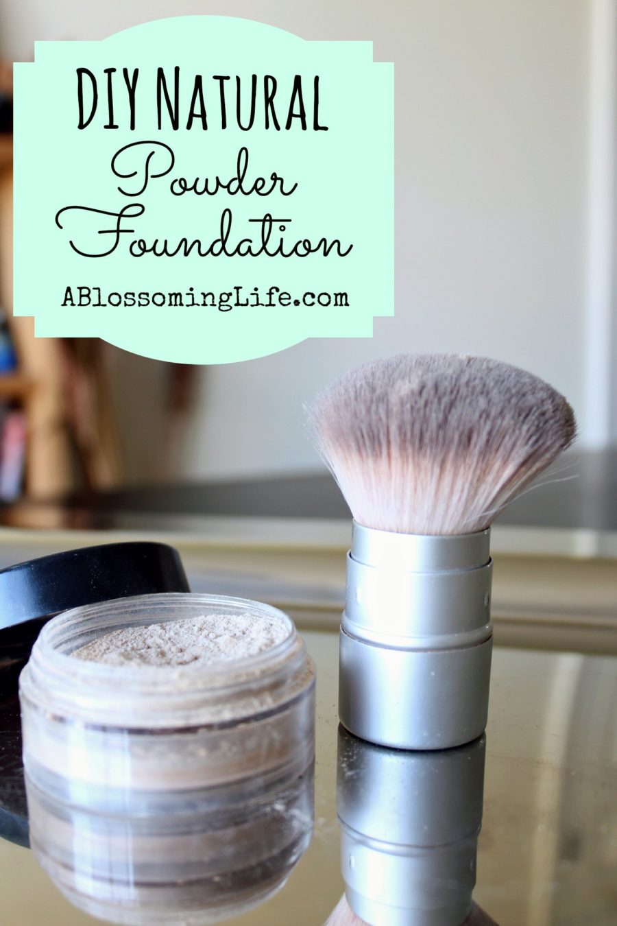 DIY Foundation in plastic container on a metal pan with a makeup brush next to it