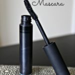 tube of natural homemade mascara on a black and white patterned plate
