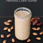homemade almond butter in a mason jar with almond and dates spread around
