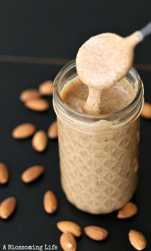 spoon drizzino almond butter into the jar of almond butter. Almond spread around the counter