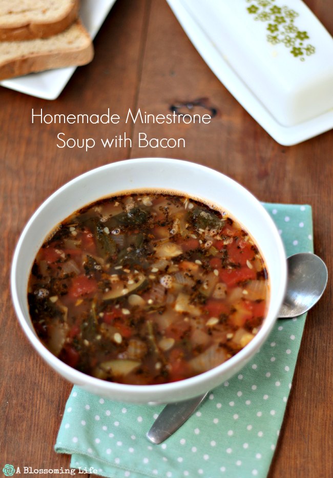 bowl of minestrone soup with a polka dot napkin and spoon to the right