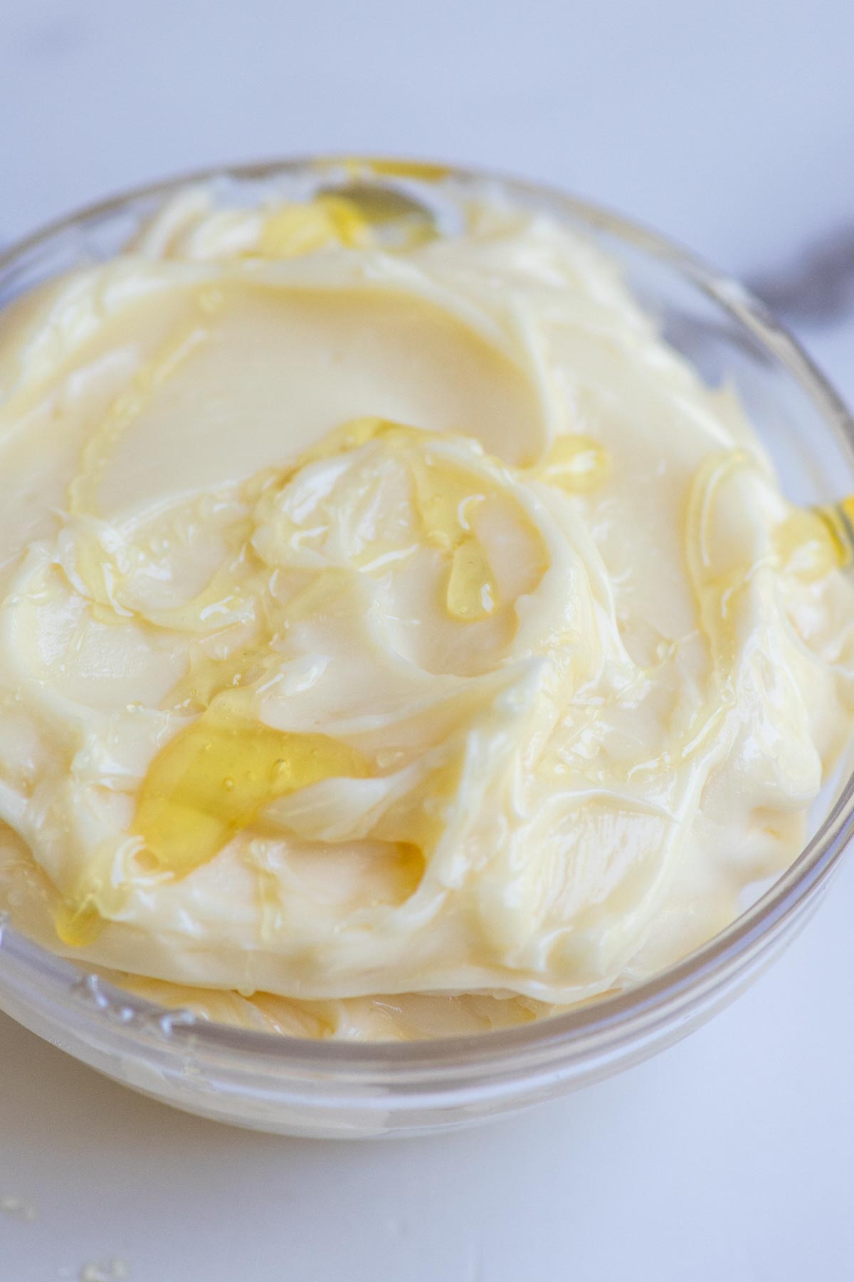 Whipped honey butter drizzled with extra honey in a glass bowl.