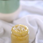 diy hand scrub in a glass jar on a white towel with a plant in the background