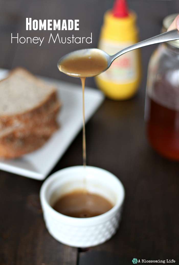 homemade honey mustard sauce in a white dish with a spoon drizzling it