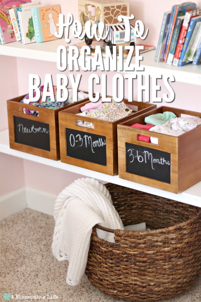 baby clothes organized by month in wooden boxes with chalkboard fronts