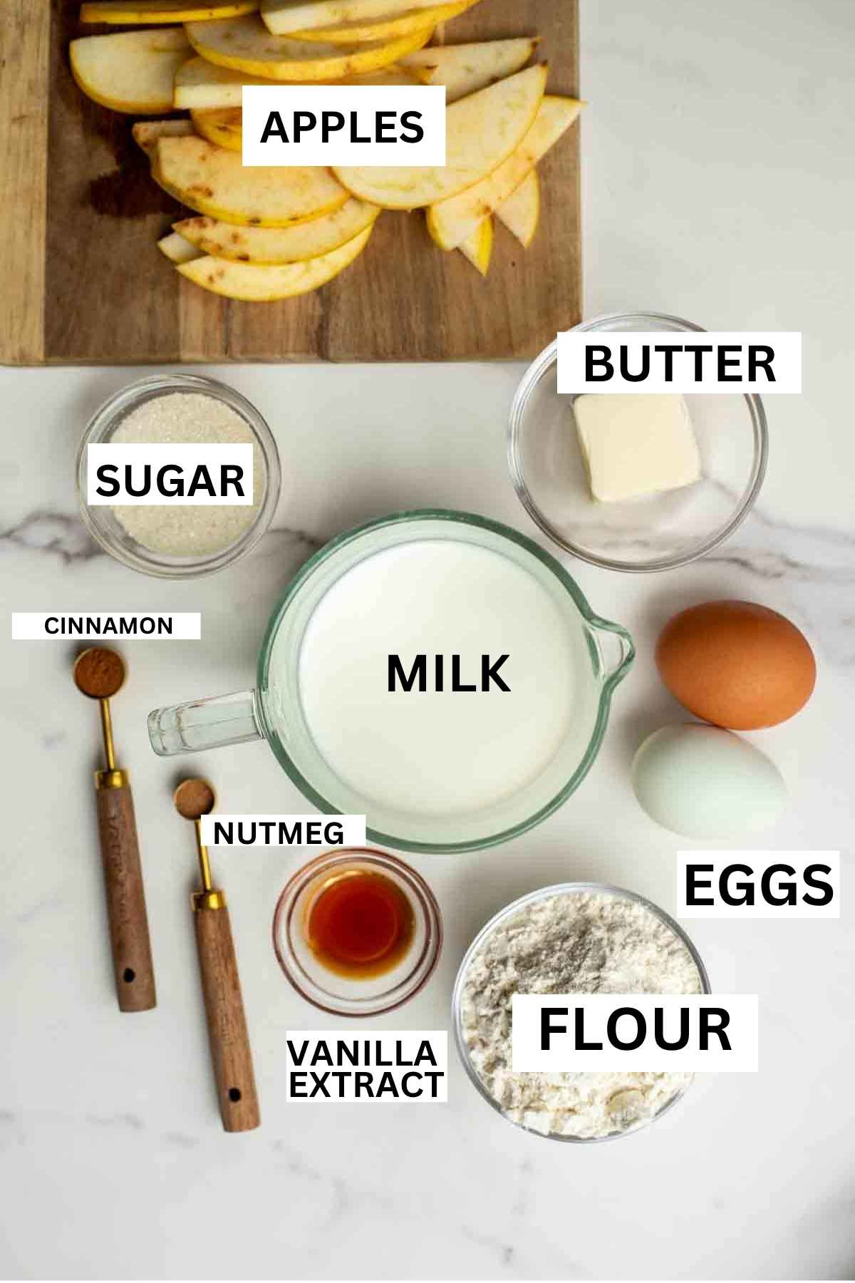Sliced apples, a small bowls of flour, sugar, vanilla, and more on a countertop.