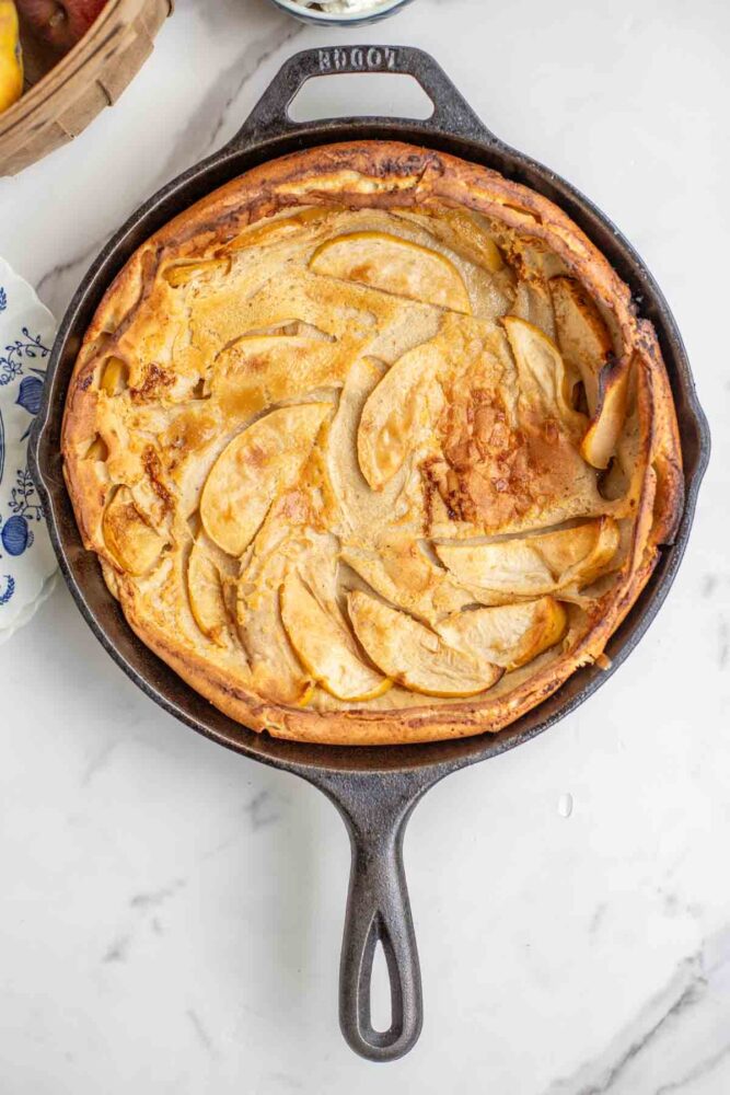 baked apple Dutch baby pancake in a cast iron skillet.