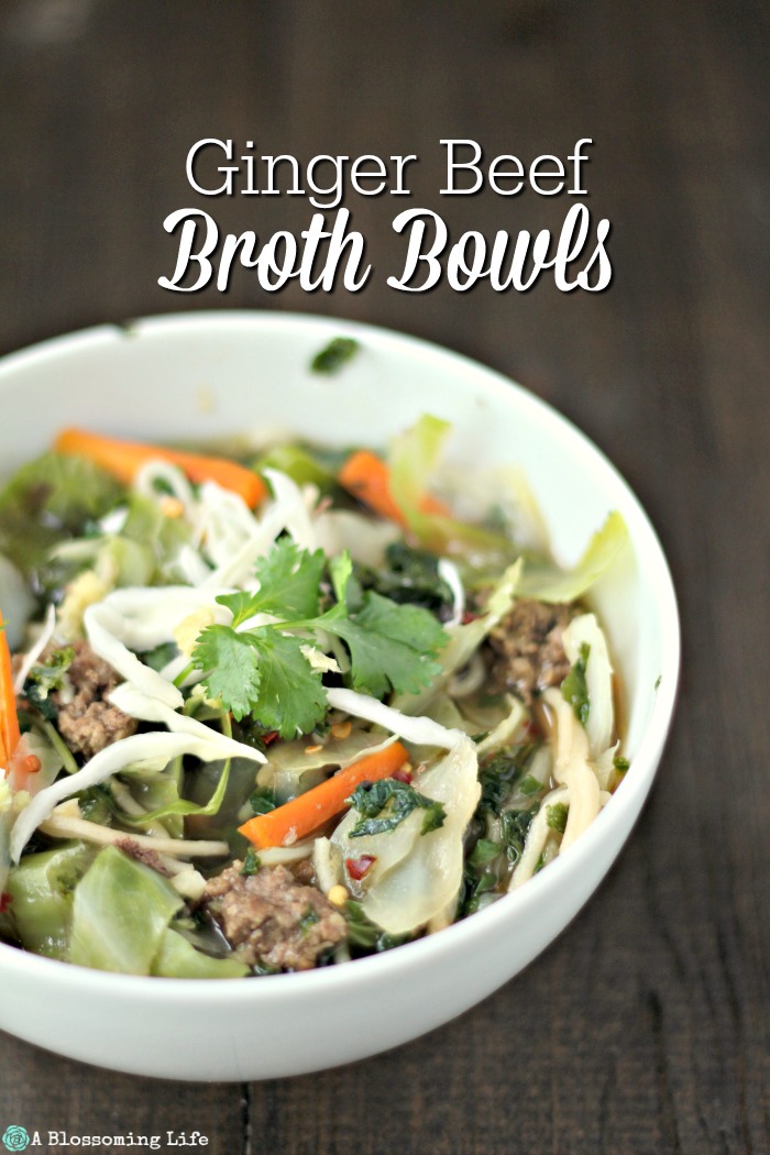 Asian Beef Noodle Soup topped with cilantro in a white bowl on a wood table.