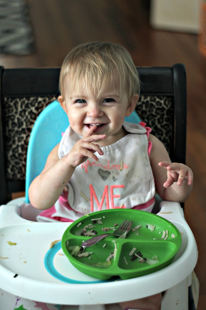 little girl eating Asian Beef Noodle Soup in a high chair