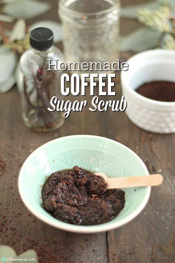 bowl of DIY coffee scrub with coffee grounds, jar of coconut oil, eucalyptus, and a jar of vanilla beans in the background.