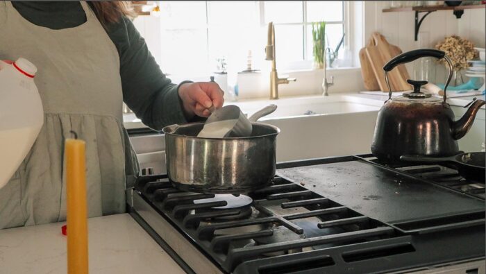 Pouring milk and other ingredients in a pot.