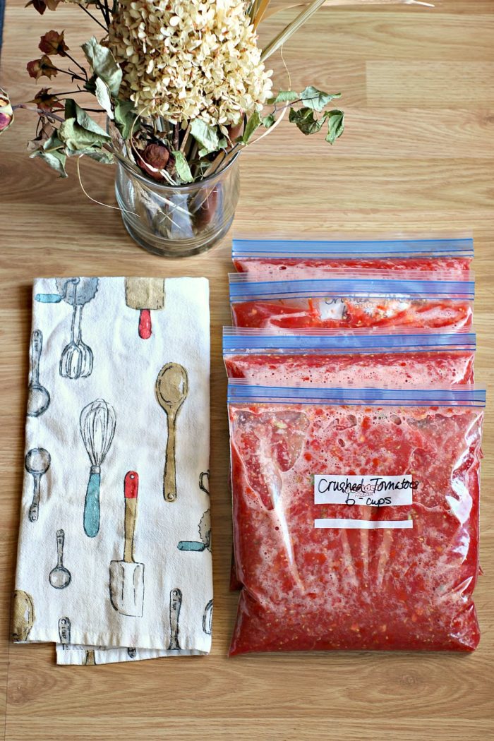 crushed tomatoes in plastic bags getting ready for the freezer