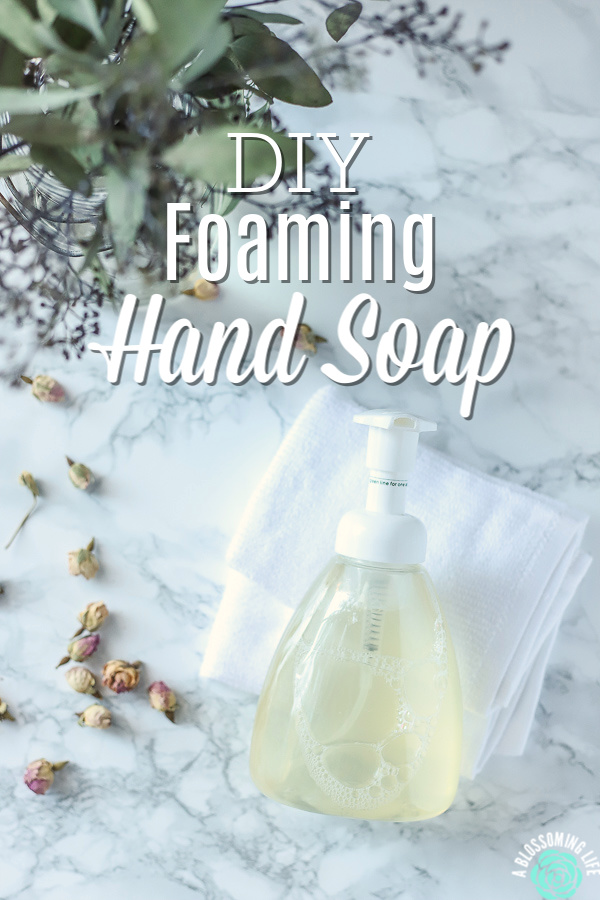 Foaming hand soap on a white wash clothes with eucalyptus leaves and dried roses to the left