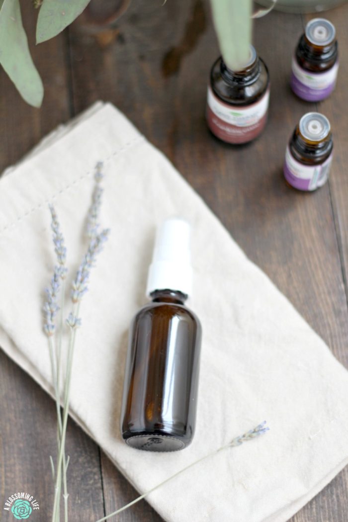 DIY perineum spray laying on a tan napkin with lavender to the left and essential oil to the right