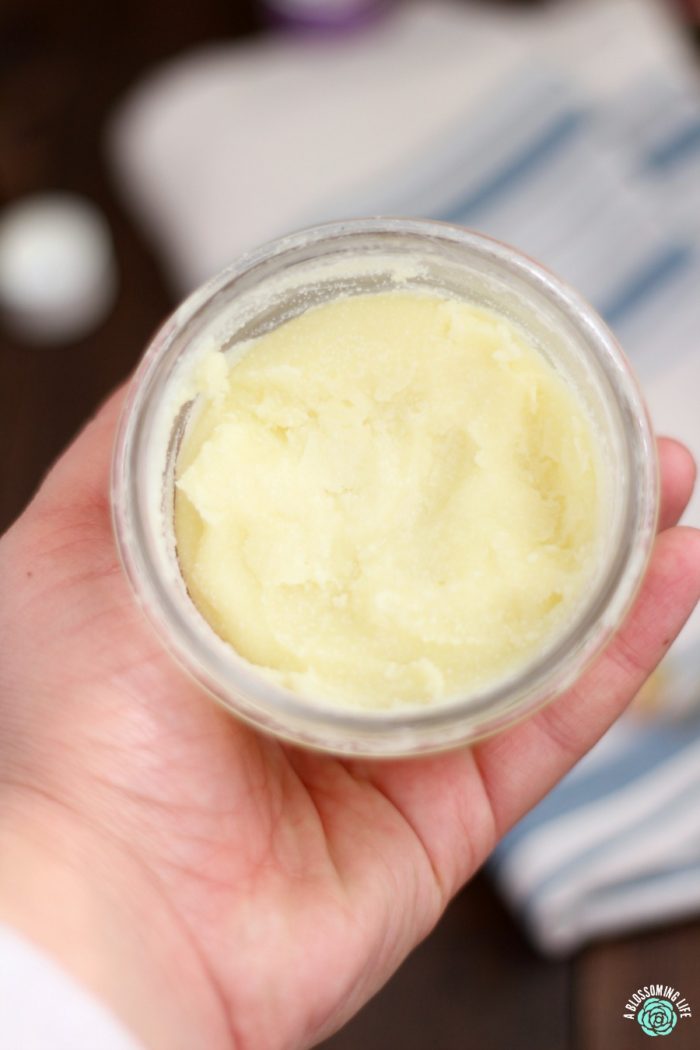 hand holding a jar of homemade healing salve