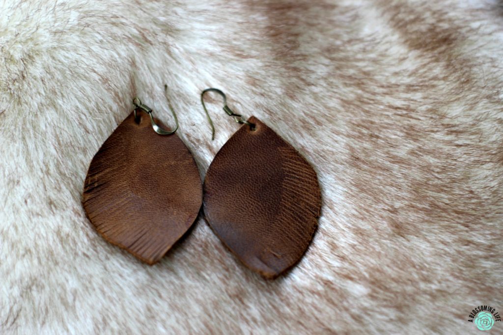 pair of brown DIY leather earrings laying on faux fur