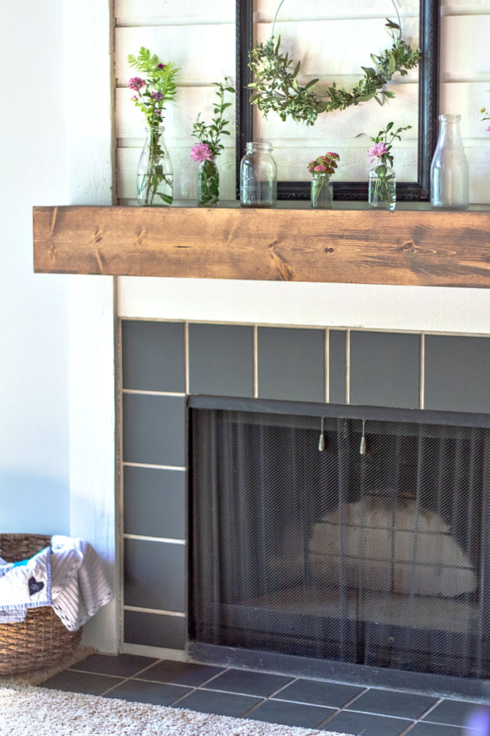 DIY fireplace mantel on a white fireplace with black tiles