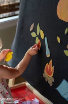 girl playing with a fall and camping themed felt board