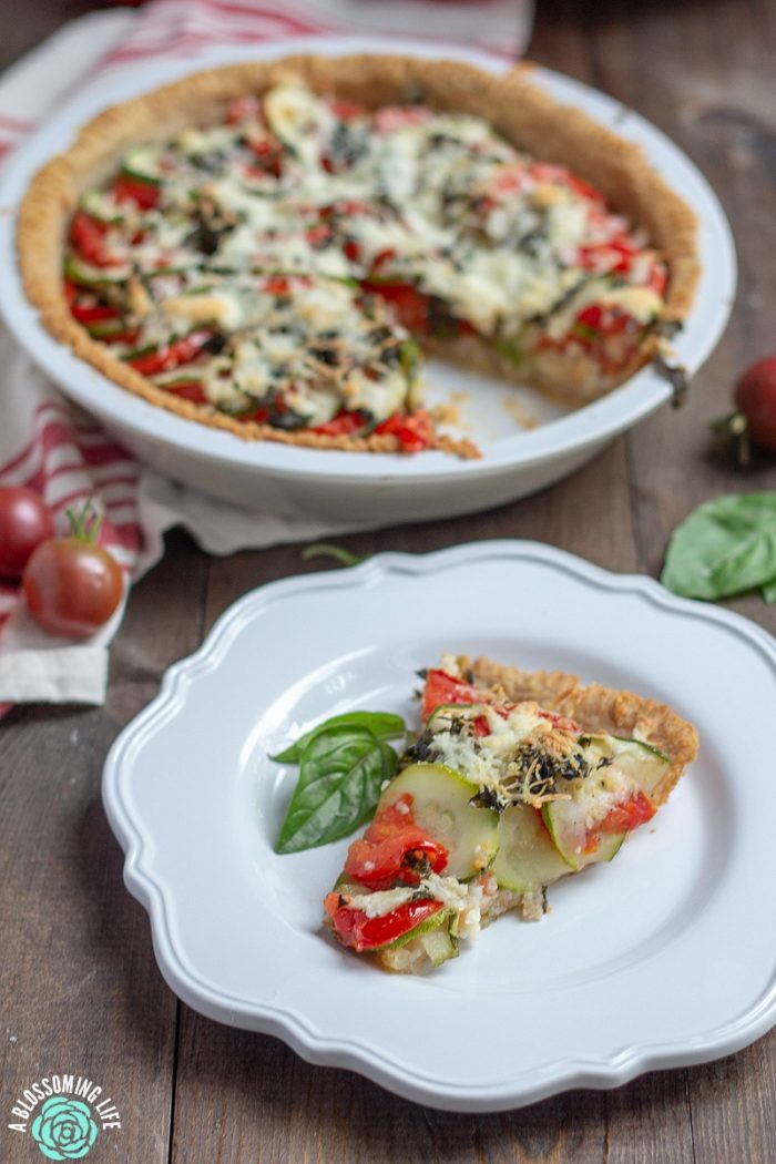 This tomato pie recipe has a perfectly flaky and buttery pie crust that is loaded with tomatoes and zucchini and a touch of garlic and cheese to make this delicious savory pie. Great recipe for when your garden is beaming with fresh zucchini and tomatoes.