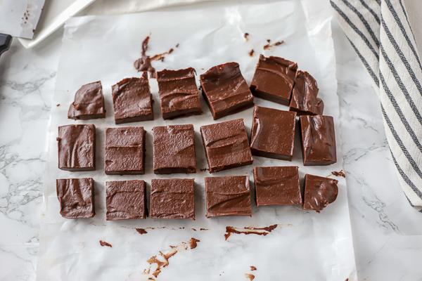 vegan fudge sliced into square pieces on white parchment paper