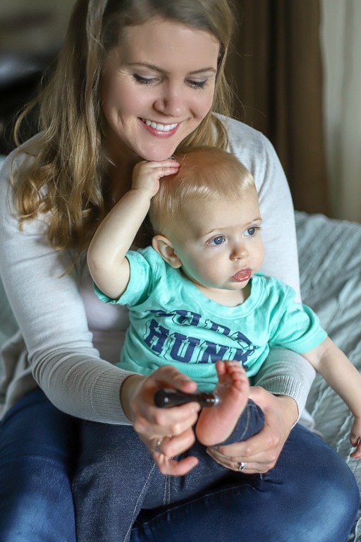 mom putting essential oils on toddlers feet