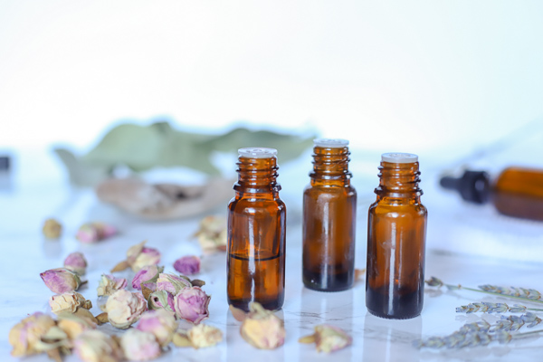 3 bottles of essential oils with dried plants around