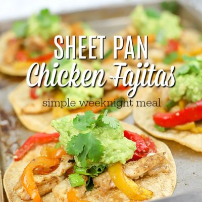 sheet pan chicken fajitas on corn tortillas on a baking sheet with more fajitas behind it