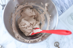 chocolate whipped cream in a silver bowl with a red spatula