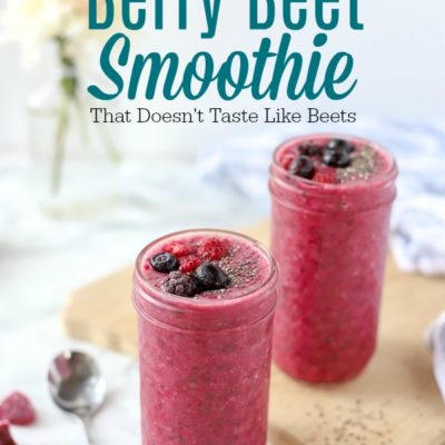 Berry beet smoothie in glass mason jars topped with chia seeds and berries on top a marble countertop