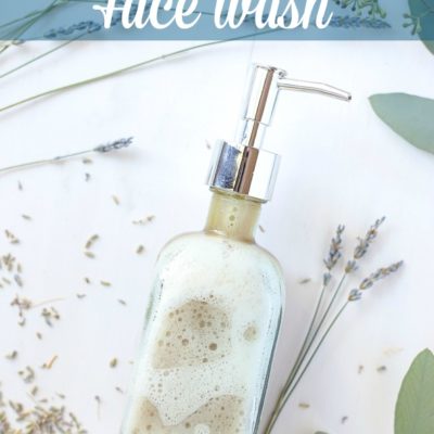 homemade face wash in a glass soap pump with dried lavender around the DIY face wash