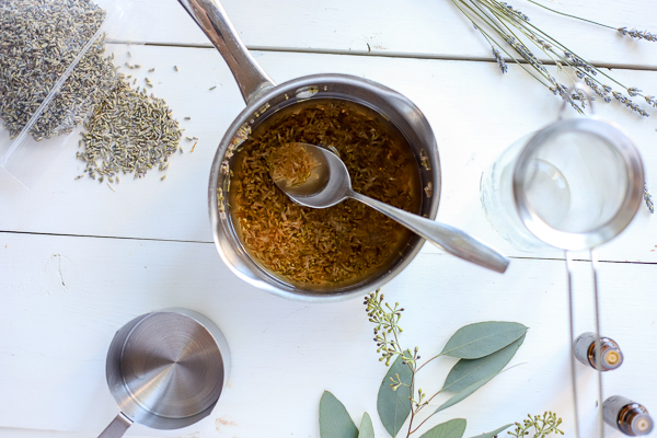 lavender water for homemade face wash in a saucepan with herbs around it