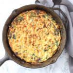 spinach frittata in a cast iron skillet with gray napkin