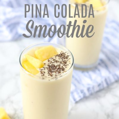 pina colada smoothie recipe in two glass cups topped with chia seeds and pineapples and placed on a blue and white napkin.