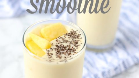 pina colada smoothie recipe in two glass cups topped with chia seeds and pineapples and placed on a blue and white napkin.