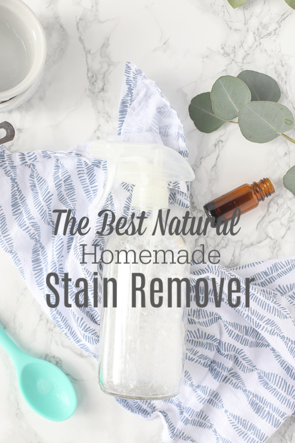 Natural homemade stain remover in a glass bottle on a blue and white napkin
