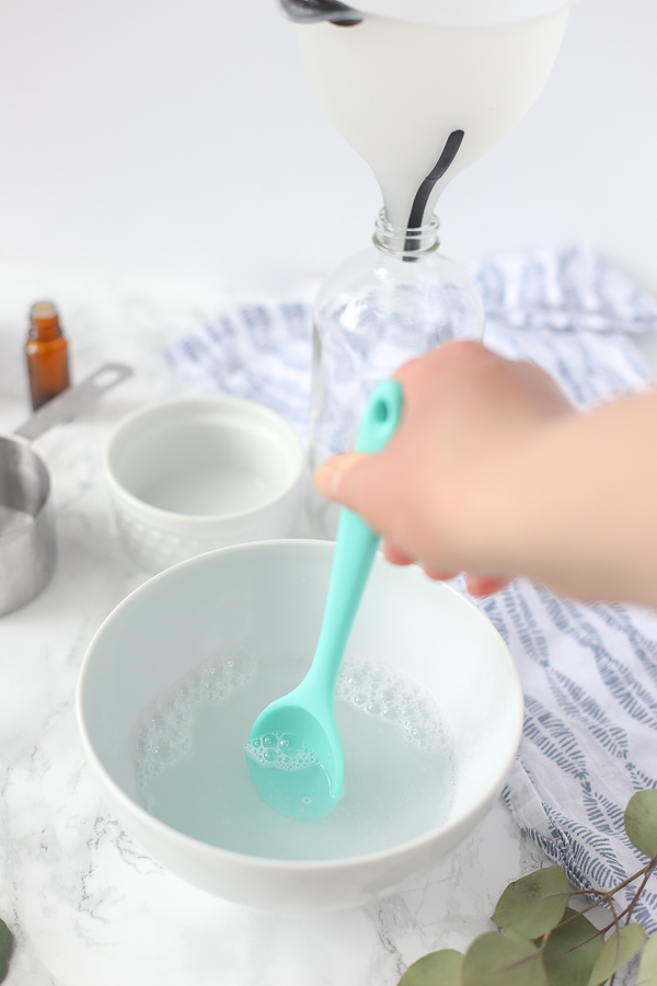 mixing ingredients together to make diy stain remover with a teal spoon