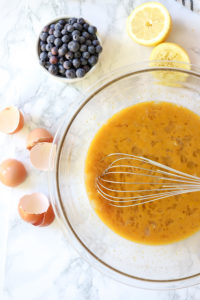 lemon curd in a glass bowl with ingredients around it
