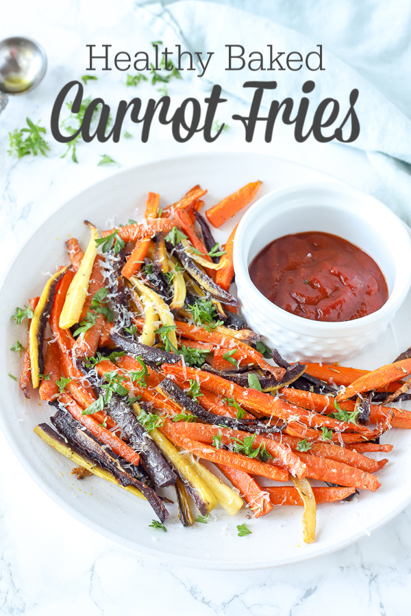 colorful baked carrot fries sprinkled with parsley and cheese on a white plate with ketchup 