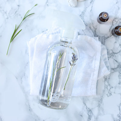 homemade air freshener in a glass bottle laying on white rags