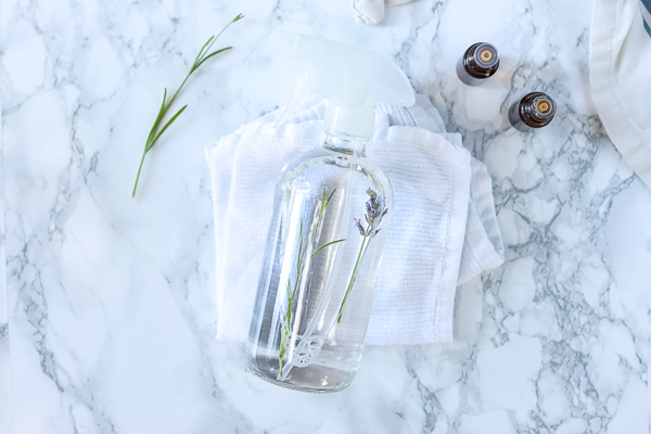 homemade air freshener in a glass bottle laying on white rags