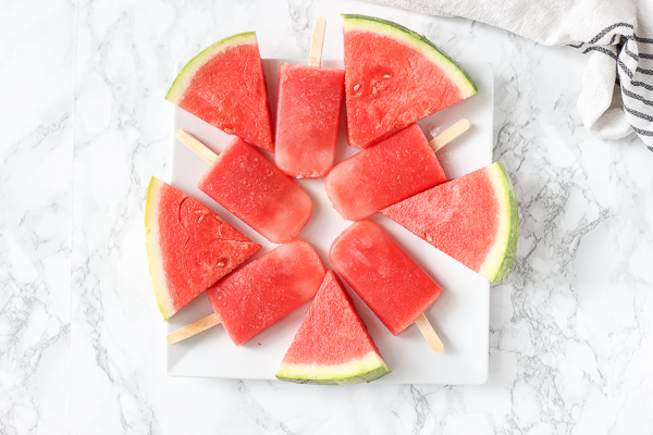 watermelon and watermelon popsicles on a white plate
