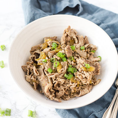 Italian beef recipe in a bowl on top a blue napkin with antique forks