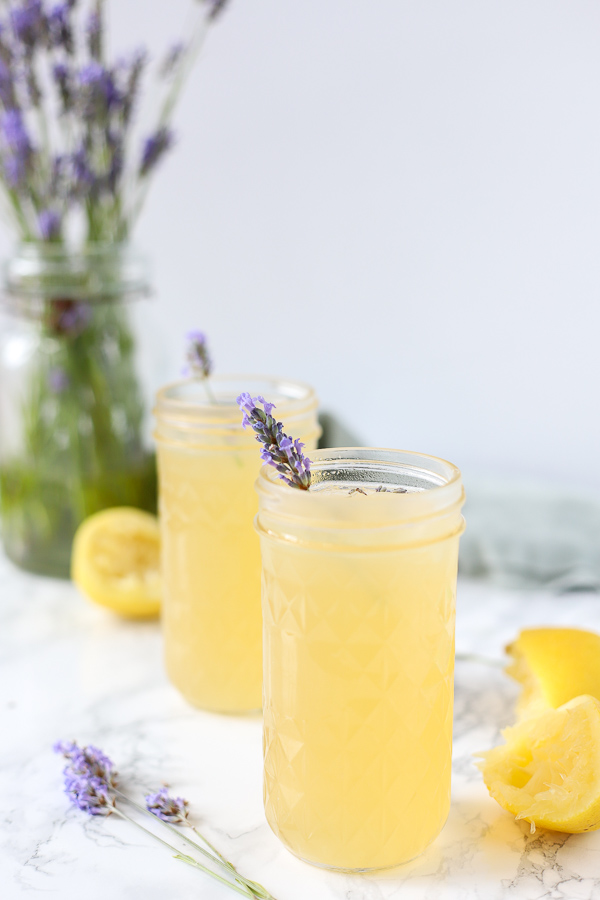 2 glasses of lavender lemonade with fresh lavender sprig as garnish