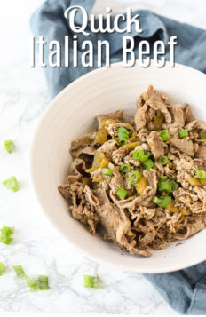 Chicago style Italian Beef in a white bowl and topped with green onions