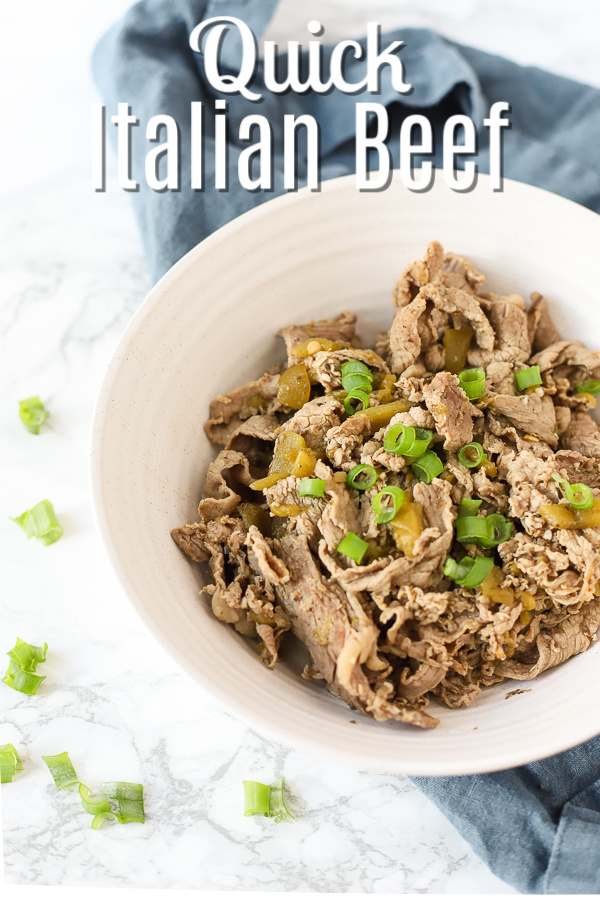 Chicago style Italian Beef in a white bowl and topped with green onions