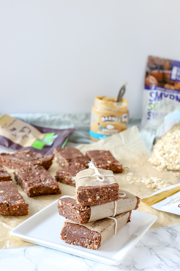 homemade double chocolate energy bars stacked up with more bars and ingredients behind it - healthy snack ideas for kids