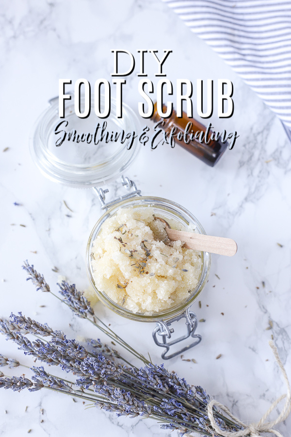 diy foot scrub in a glass jar with lid, Wooden spoon in scrub with a dried bunch of lavender next to the jar