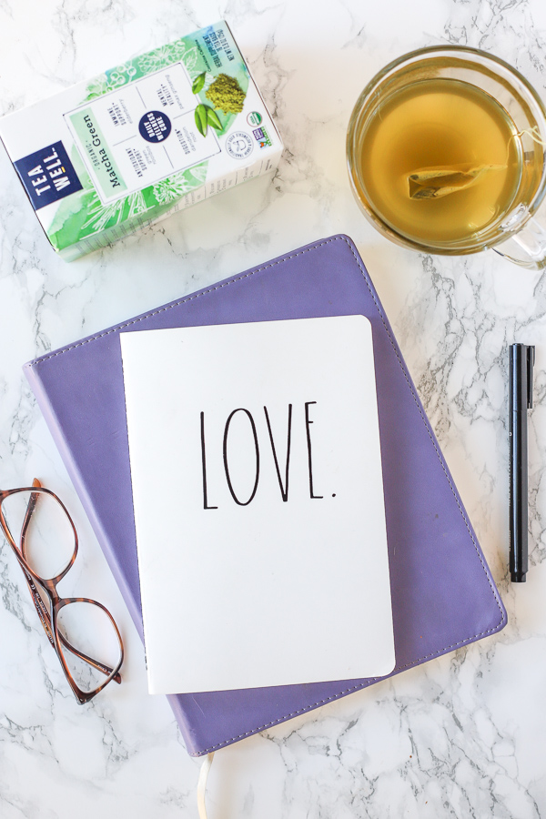 two journals stacked up with glasses to the left and a mug of TeaWell tea behind. Self-Care Tips