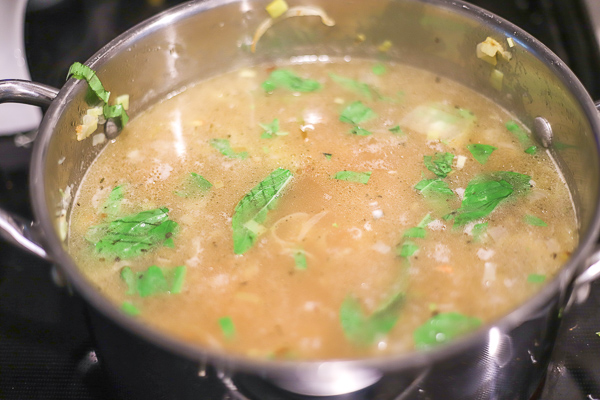 simmering potato leek soup in a large soup pot